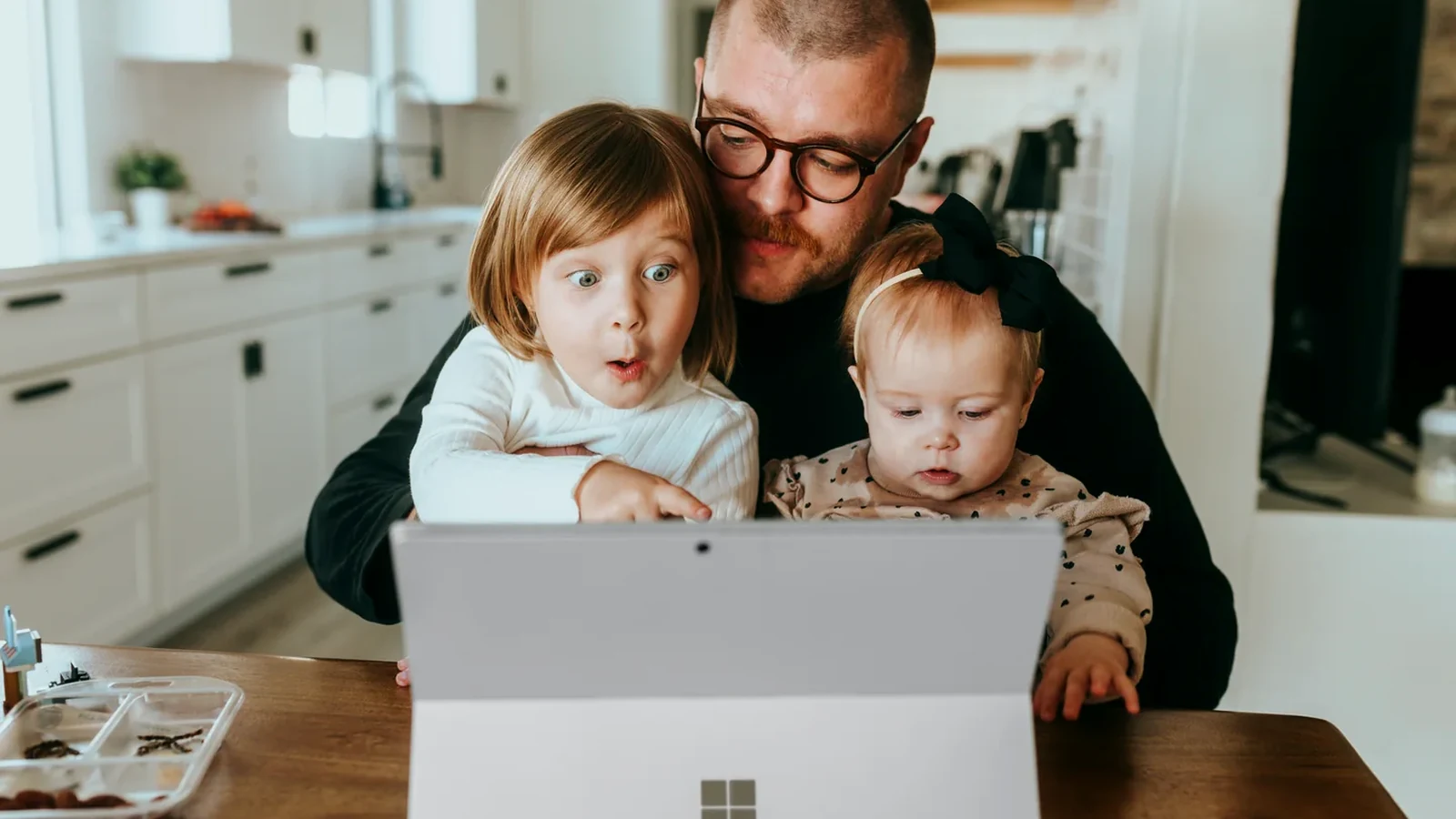 Ein Vater lernt gemeinsam mit zwei Kindern an einem digitalen Gerät