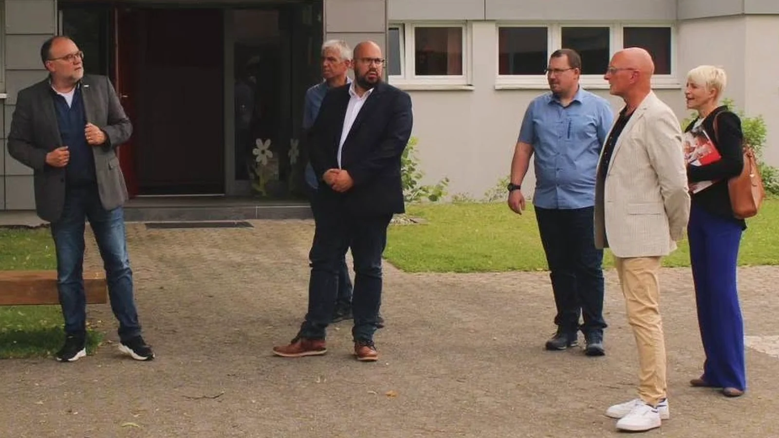 Mehrere Personen stehen bei einem Gespräch während des Bürgermeisterwahlkampfs im Freien zusammen